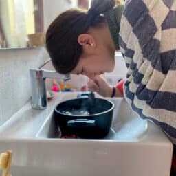 Woman breathing in steam from a large bowl of water