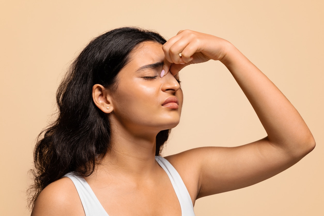 Woman holding her tender sinuses.