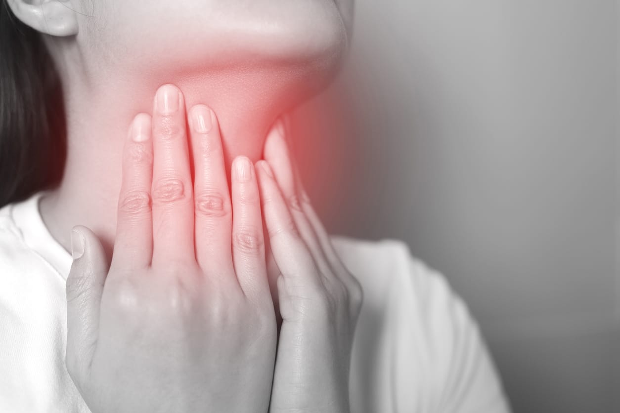 Throat pain concept, girl holding her red throat.